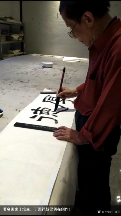 丁国祥生活-与叔叔著名画家丁培生同在一张案台创作！
叔叔丁培生在书写《厚德载物》，我在画竹【图1】