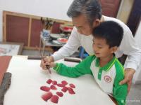 艺术家罗树辉生活:教外孙画红棉花。是完成学校的任务。外孙很聪明，有慧根！很棒！【图1】
